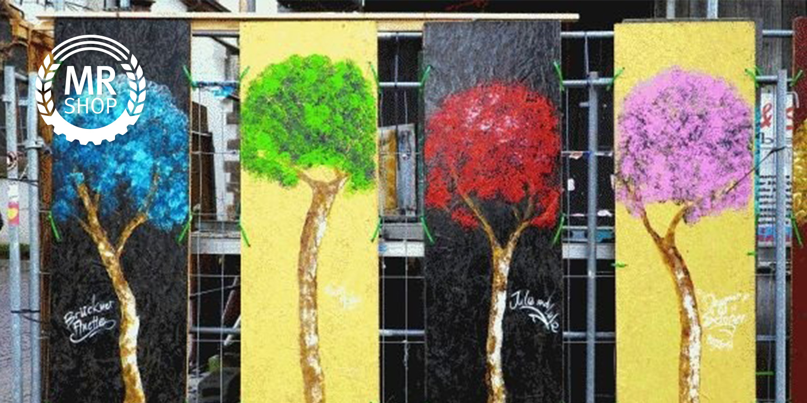 Bauzaun mit Bildern von Bäumen