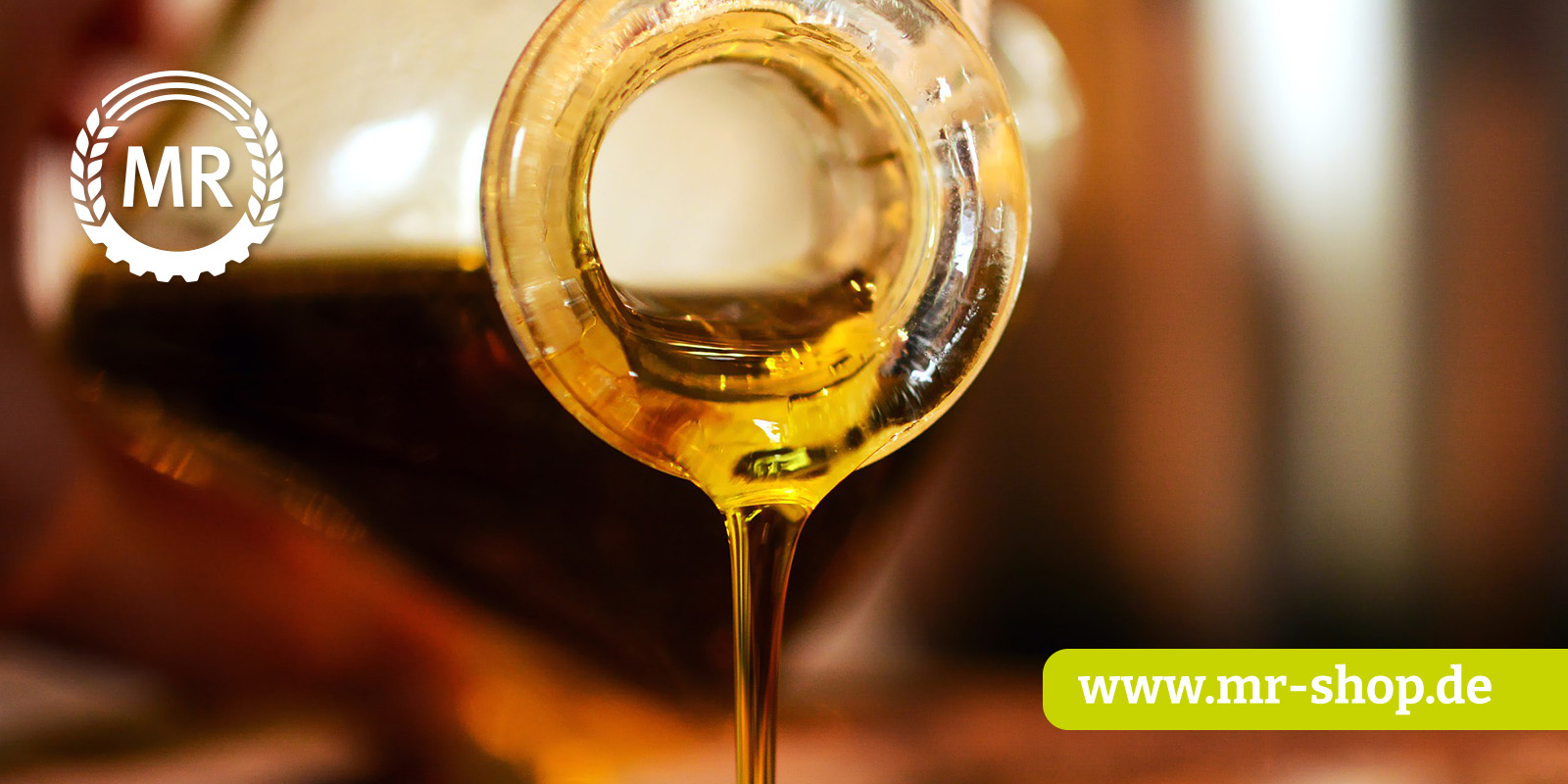 Goldenes Öl wird aus einer Glasflasche ausgeschüttet